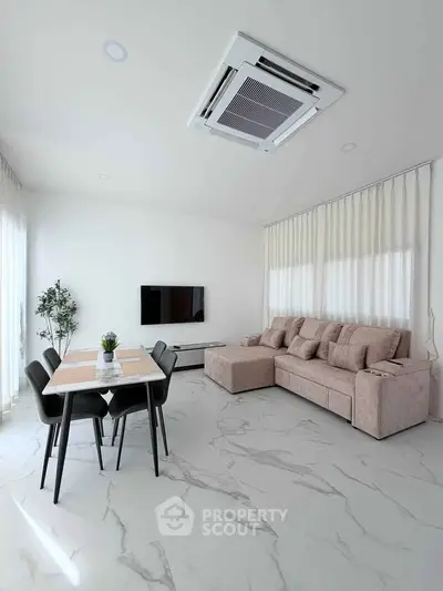 Modern living room with sleek furniture and marble flooring, featuring a cozy sofa and dining area.