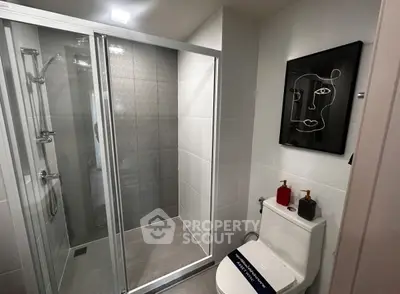 Modern bathroom with glass shower and stylish wall art