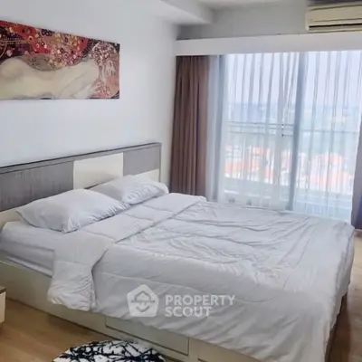 Bright bedroom with large window and modern decor in a high-rise apartment.