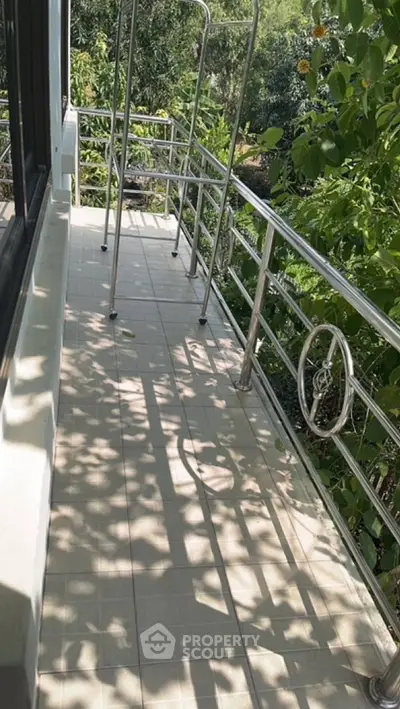 Spacious balcony with lush green view and modern railing design