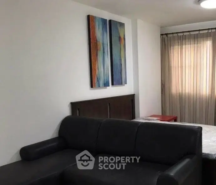 Cozy living room with modern art and comfortable black sofa