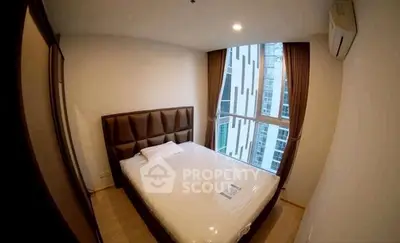 Cozy bedroom with large window and modern decor in urban apartment