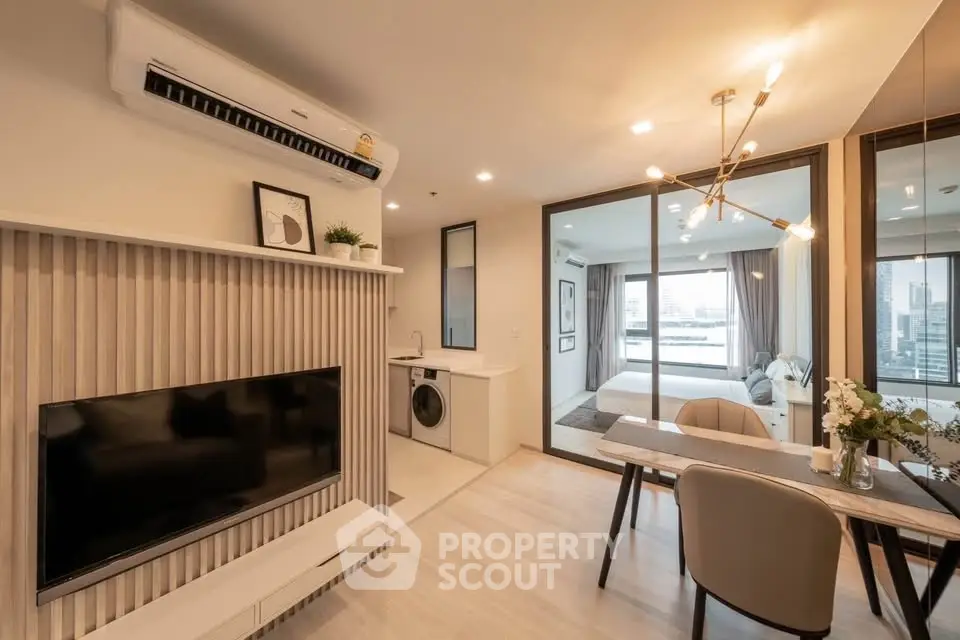 Modern open-plan living room with stylish decor and city view, featuring a dining area and bedroom access.