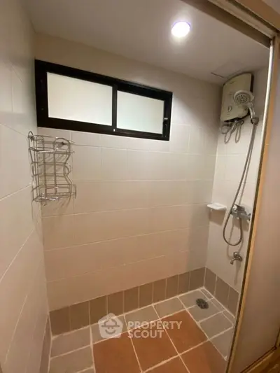 Modern bathroom with shower and tiled walls in a real estate property