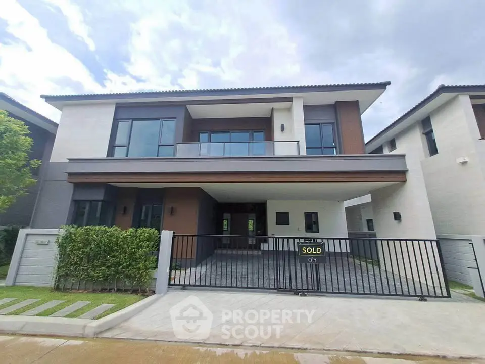 Modern two-story house with sleek design and spacious driveway in a serene neighborhood.