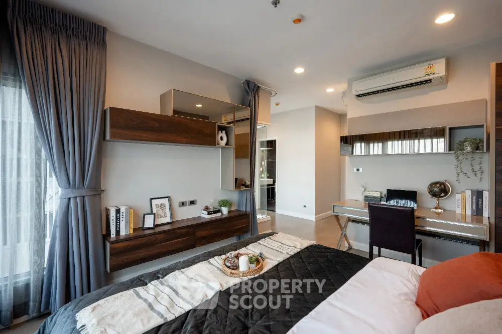 Modern bedroom with stylish decor and workspace, featuring elegant shelving and cozy bedding.