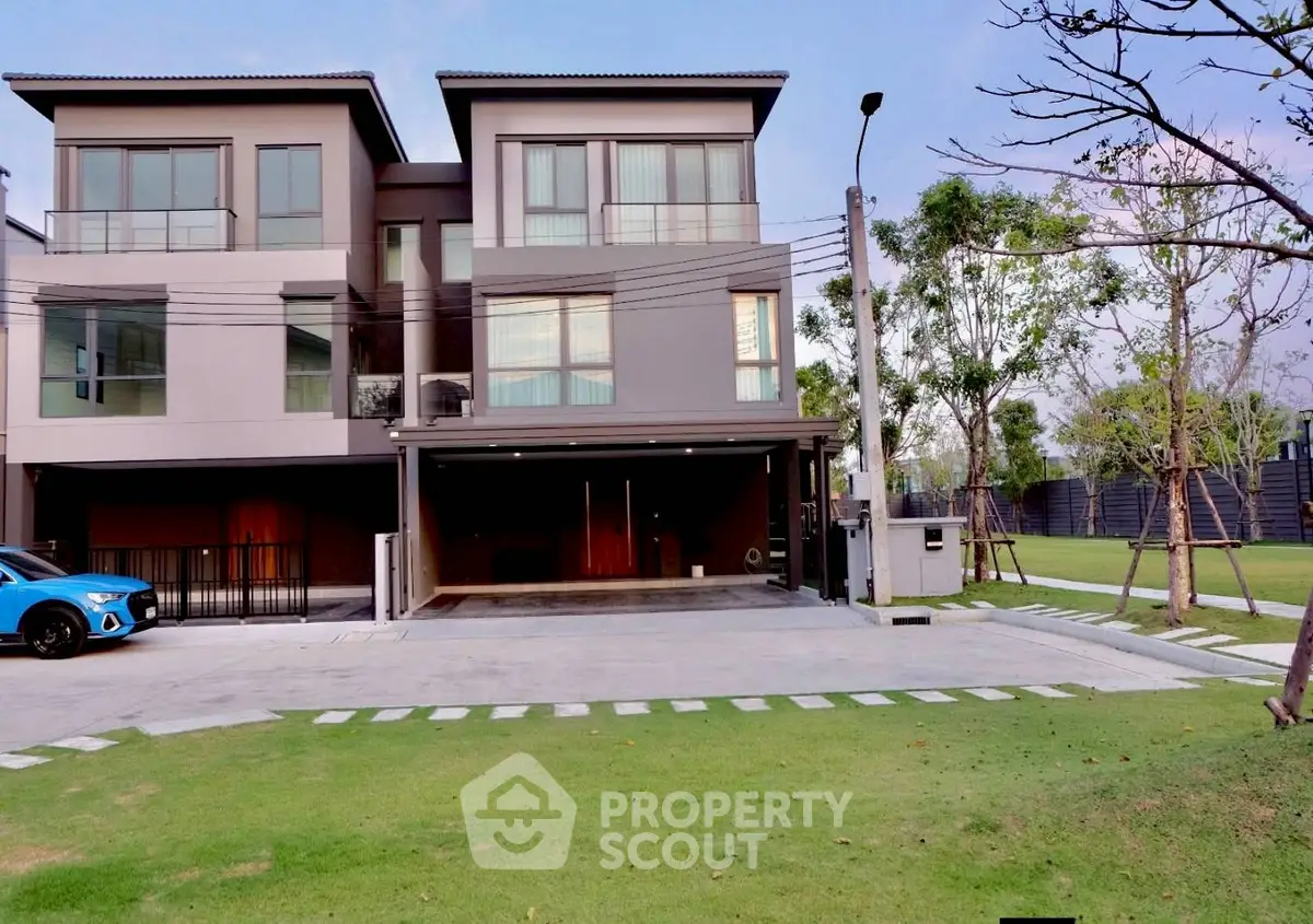 Modern three-story townhouse with spacious driveway and lush green lawn