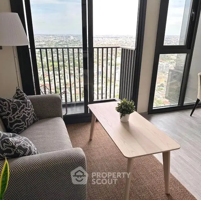 Chic living room with stunning city view from high-rise balcony, modern decor and cozy ambiance.