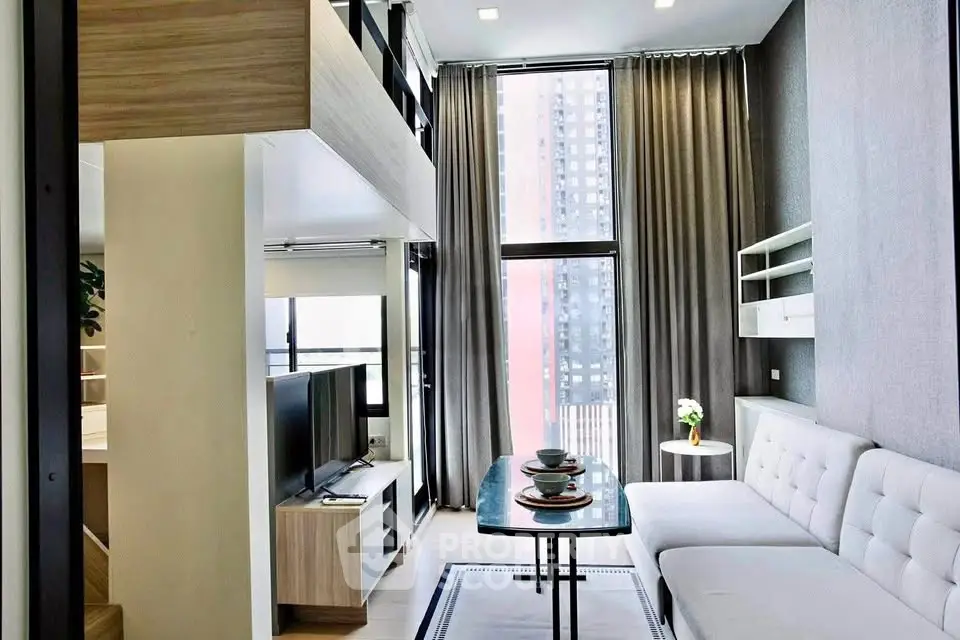 Modern living room with high ceilings and large windows in a stylish apartment.