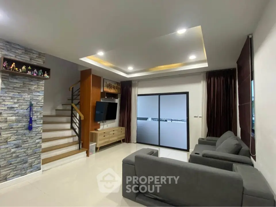 Modern living room with sleek design, cozy seating, and stylish staircase in a contemporary home.
