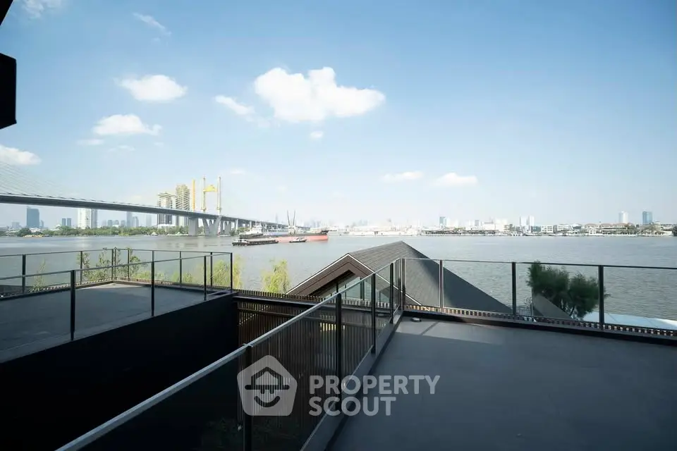Stunning riverfront view from a modern balcony with city skyline backdrop.