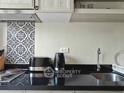 Modern kitchen with sleek black countertop and stylish backsplash