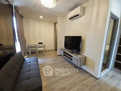 Modern living room with sleek design, featuring a wall-mounted TV and air conditioning.
