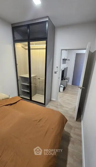 Modern bedroom with sleek wardrobe and cozy decor, perfect for urban living.