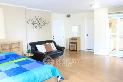 Spacious bedroom with modern decor and open layout in a bright apartment.