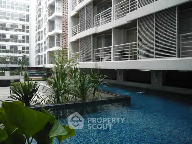 Modern apartment complex with a luxurious swimming pool and stylish architecture.