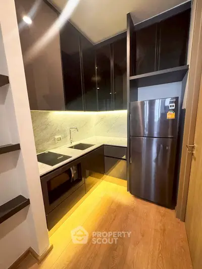 Modern kitchen with sleek cabinetry and stainless steel appliances in a compact layout.