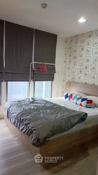 Cozy bedroom with modern decor and large windows in a stylish apartment.