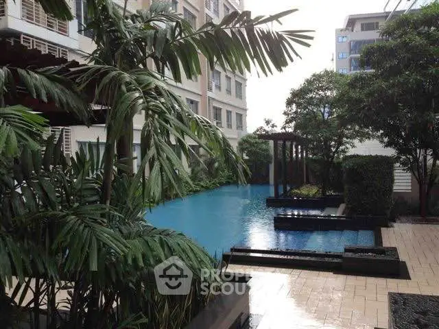 Luxurious apartment complex with serene pool and lush greenery, perfect for relaxation and leisure.