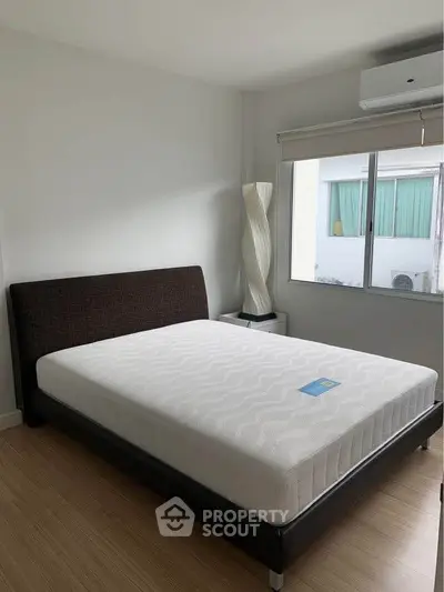 Modern bedroom with large window and stylish floor lamp