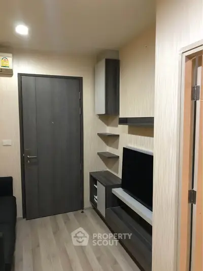 Modern apartment entrance with sleek storage and TV unit