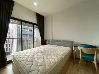 Modern bedroom with balcony access in a stylish apartment, featuring a comfortable bed and sleek furniture.