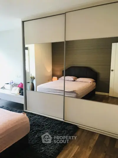 Modern bedroom with mirrored sliding wardrobe and cozy decor