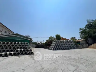 Spacious industrial property with ample outdoor storage space and clear blue sky.