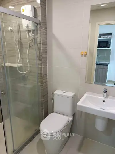 Modern bathroom with glass shower and sleek fixtures in a contemporary apartment.