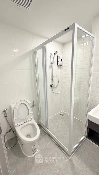 Modern bathroom with glass shower enclosure and sleek fixtures