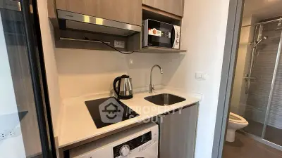 Compact modern kitchen with appliances including washing machine and microwave, ideal for urban living.