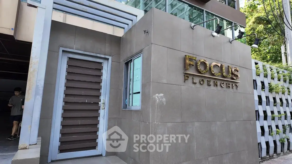 Modern building entrance with sleek design and prominent signage in urban setting.