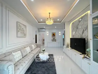 Luxurious living room with elegant chandelier and plush sofa in modern home.