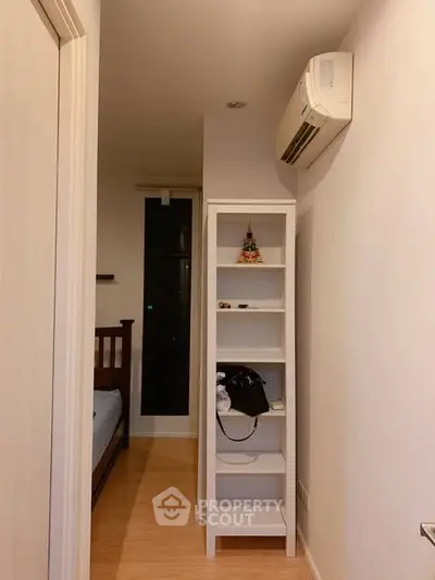 Cozy small bedroom with air conditioning and wooden flooring
