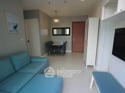 Modern living room with blue sofa and dining area in stylish apartment