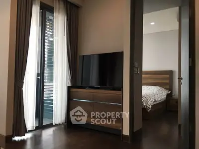 Modern bedroom with wooden furniture and balcony access in a stylish apartment.