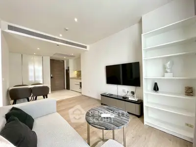 Modern living room with sleek furniture and open kitchen layout in a stylish apartment.
