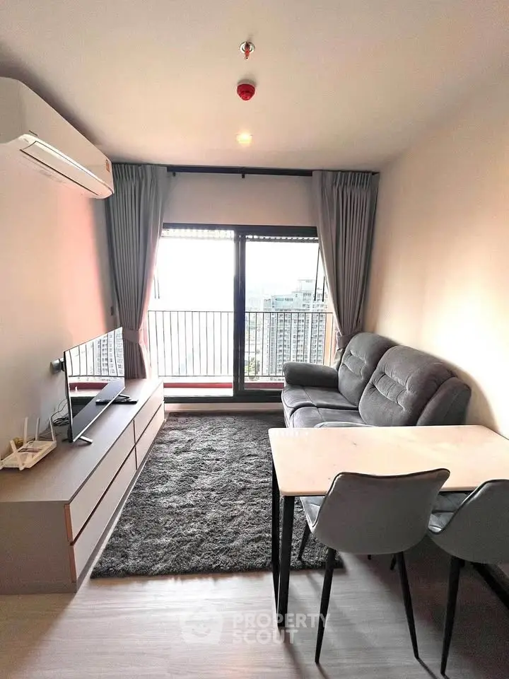 Modern living room with balcony view, featuring sleek furniture and abundant natural light.