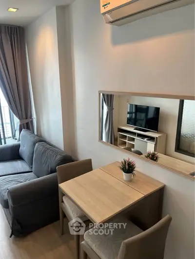 Modern living room with cozy sofa, dining table, and wall-mounted TV in a stylish apartment.