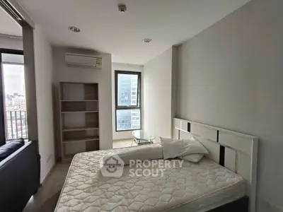 Modern bedroom with city view, featuring minimalist design and natural light.