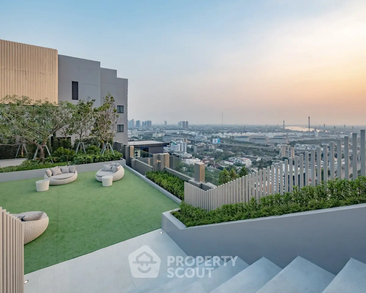 Stunning rooftop garden with panoramic city view at sunset, featuring modern seating and lush greenery.