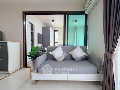 Modern living room with stylish sofa and natural light, perfect for relaxation and comfort.