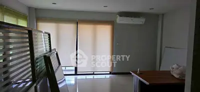 Spacious office room with large windows and air conditioning, ideal for a productive work environment.