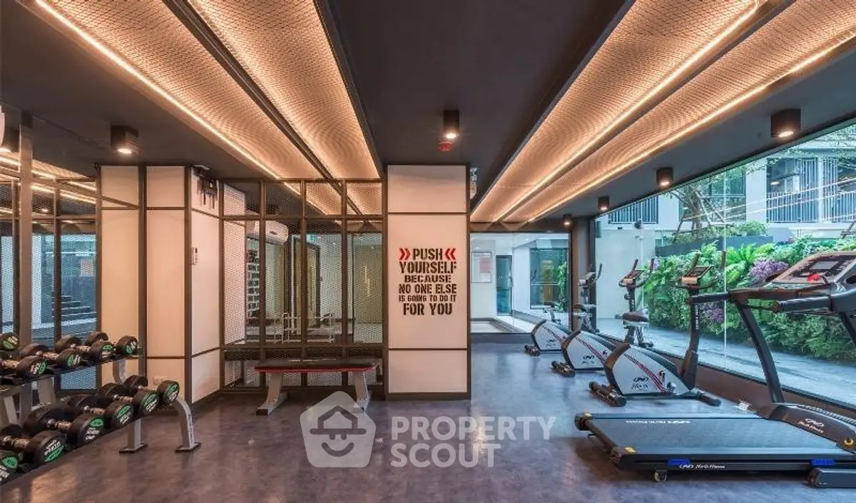 Modern gym with state-of-the-art equipment and motivational decor in luxury real estate property.