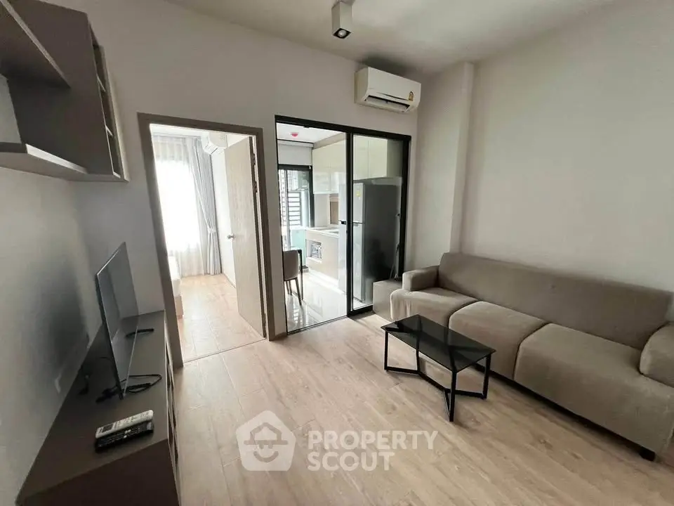 Modern living room with sleek furniture and open kitchen layout in a stylish apartment.