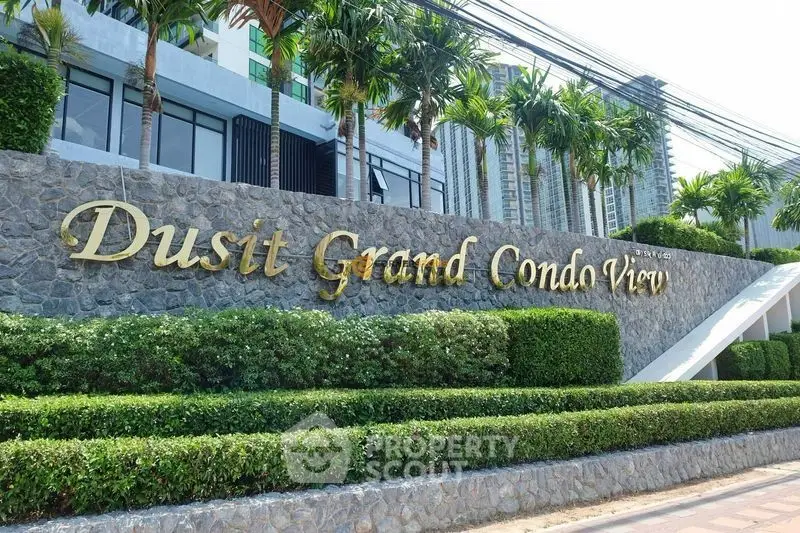Elegant entrance of Dusit Grand Condo View with lush greenery and modern architecture.
