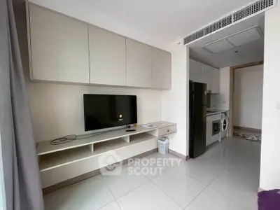 Modern apartment living room with TV and kitchen appliances