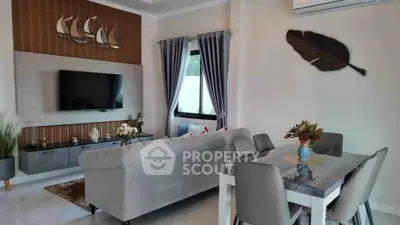 Modern living room with stylish decor and dining area, featuring a wall-mounted TV and elegant furnishings.