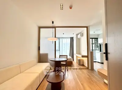 Modern living room with wooden flooring and stylish furniture in open-plan apartment.