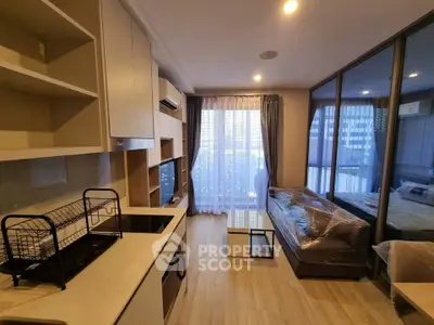 Modern living room with open kitchen and large windows in stylish apartment.